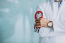 Clinician in a white coat holding a stethoscope