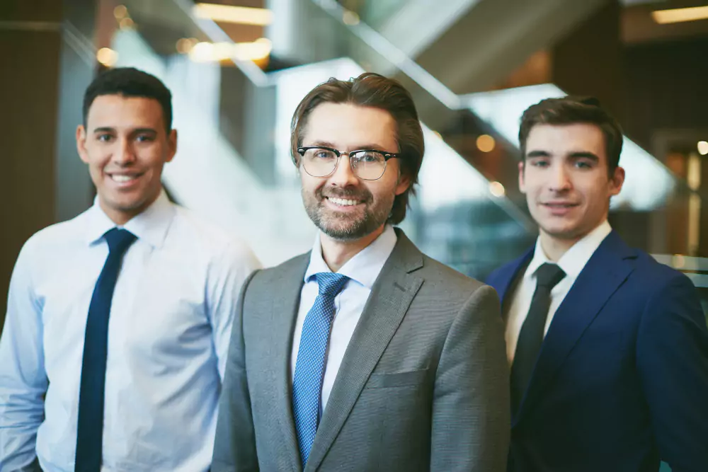 Three colleagues standing together in the office lobby