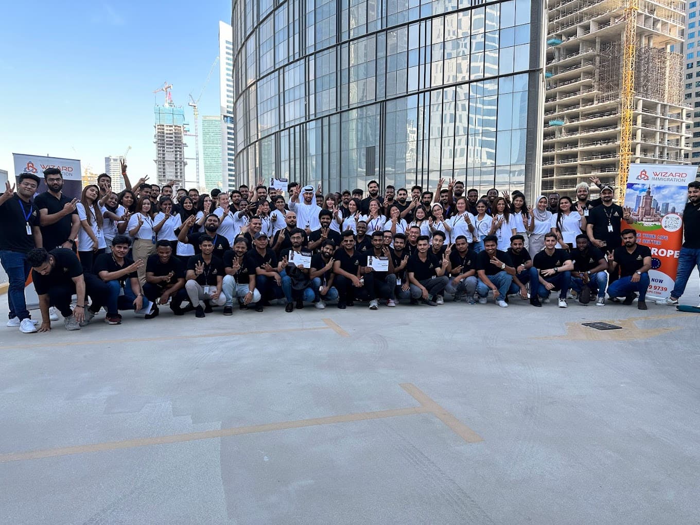 The Wizard Immigration Services team gathered outside the Business Bay office in Dubai for a full company photo